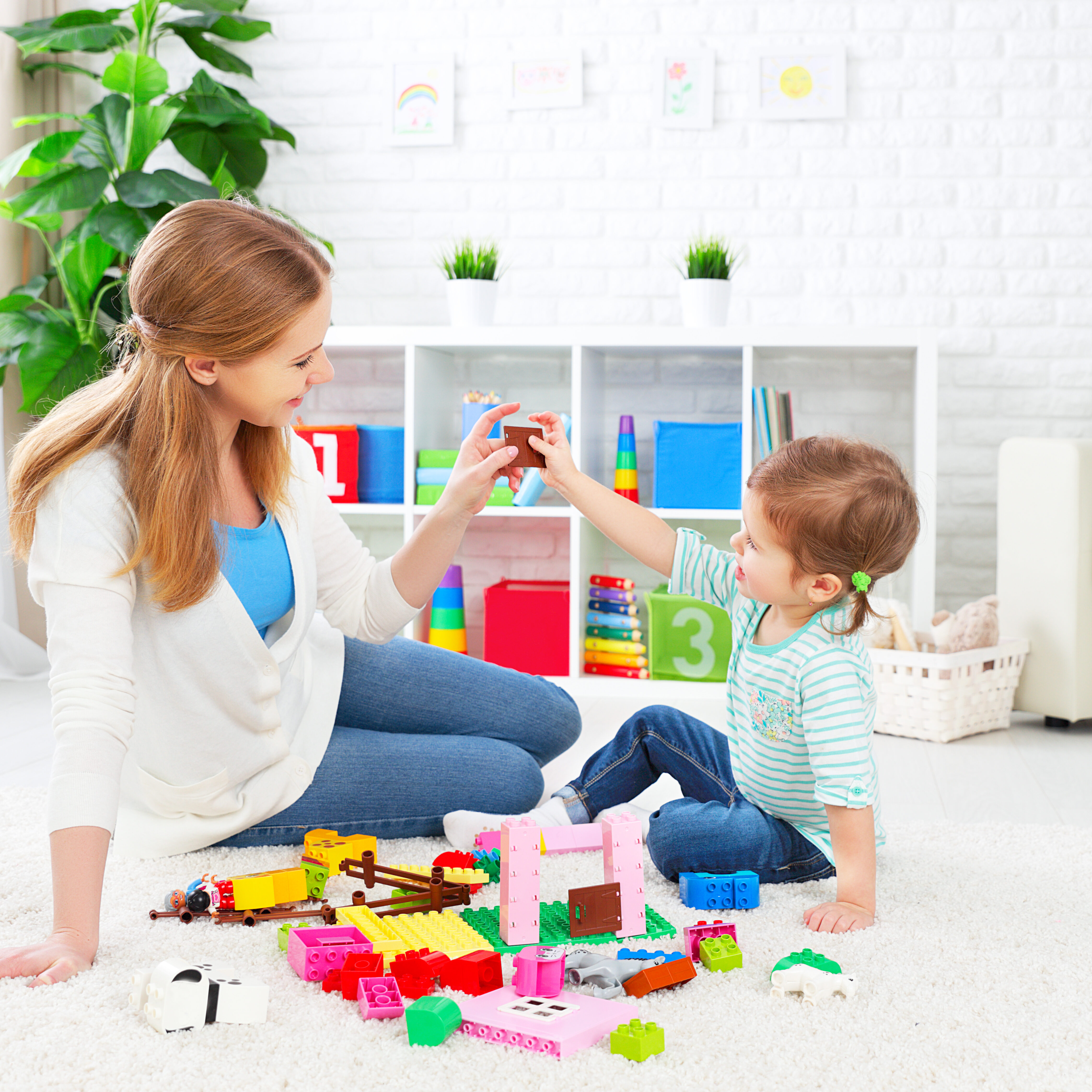 Mother and child daughter playing together, build from the constructor