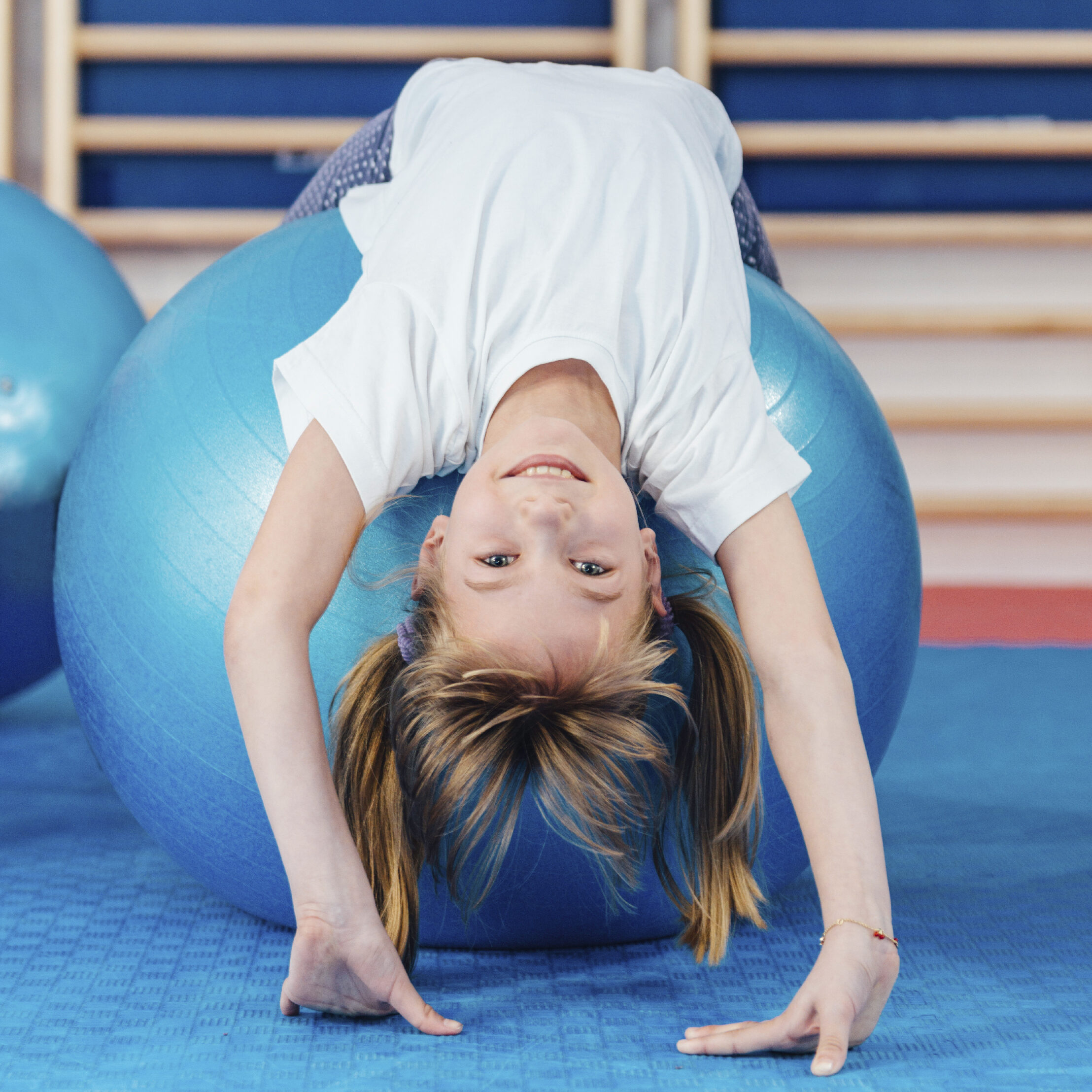 Cute girl exercising on pilates ball